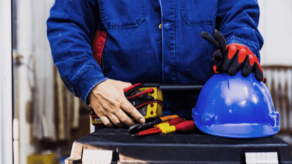 Construction worker holding tools and personal protective equipment